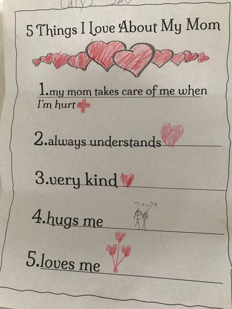 child's mother's day card with text, "5 things I love about my mom. 1. my mom takes care of me when I am hurt, 2. always understands, 3. very kind, 4. hugs me, 5. loves me." With lots of red crayon hearts.